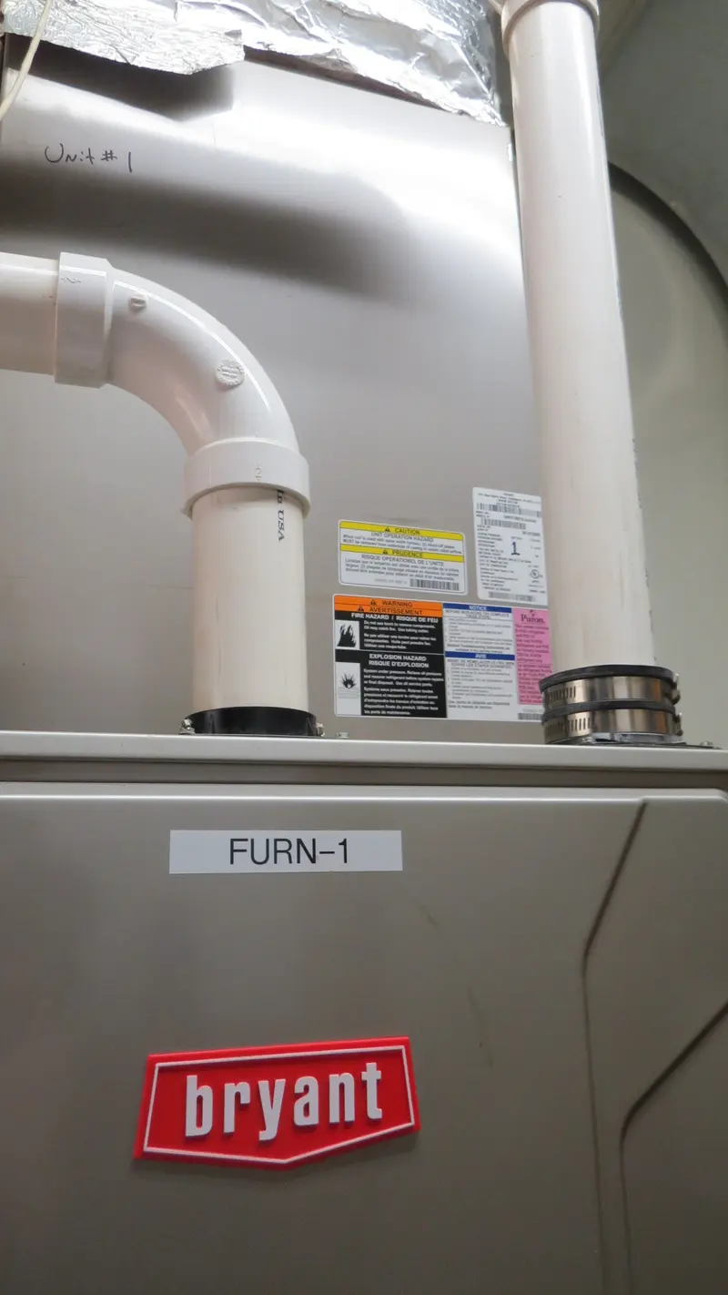 A Bryant furnace labeled FURN-1 with white vent pipes